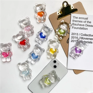 Detailed view of clear resin bear phone grips with colorful hearts on white background