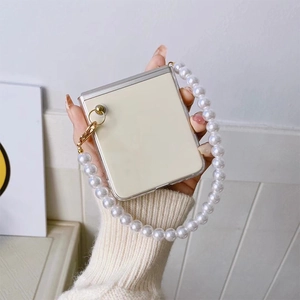 Detail of transparent Z Flip case featuring a chunky pearl handle and golden clasps