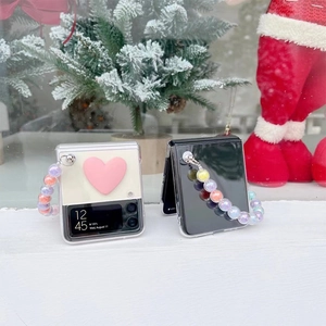 Close-up of foldable phone case featuring a colorful bead chain and pink heart ornament