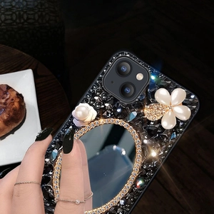 Close-up of luxury phone case with built-in makeup mirror, pearls, and crystals