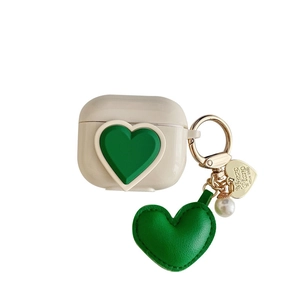 Beige AirPods case with green embossed heart and elegant pearl gold keychain
