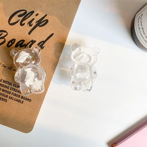 Close-up of a bear-shaped phone grip with glitter sequins and white resin details