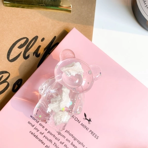 Detailed macro view of the clear resin bear phone grip with glitter and white cloud clouds