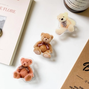 Detailed close-up of cute 3D acrylic bear phone grips with ribbon bows in soft tones