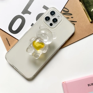 Detail of transparent 3D bear phone grip with a vibrant yellow heart on clear case