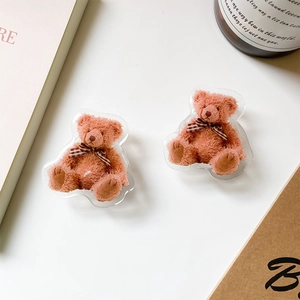 Detail of two cute teddy bear acrylic phone grips with plaid bows on white background