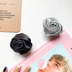 Detail of handmade satin fabric rose phone grip with metallic luster in black and grey