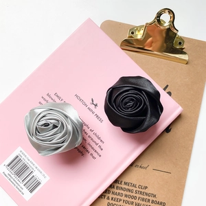 Detailed view of handmade satin fabric rose phone grips in silver gray and black colors