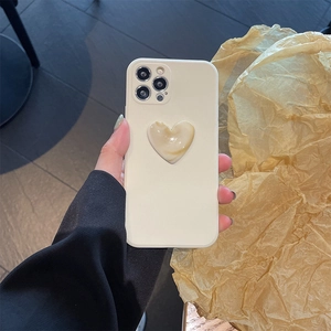 Detail of cream iPhone case featuring a marble textured heart-shaped grip held by hand