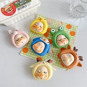 Macro detail of six cute 3D resin pigs in animal hoodies used as phone grip stands