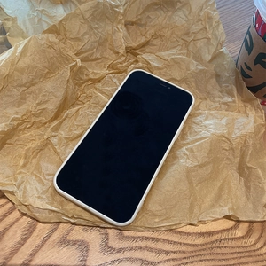 White liquid silicone phone case for iPhone placed on wrinkled kraft paper background