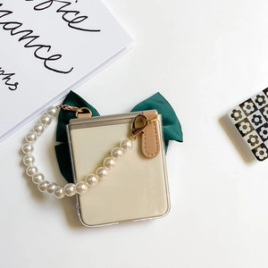 Detail of Galaxy Z Flip case with large dark green bow and white pearl handle strap