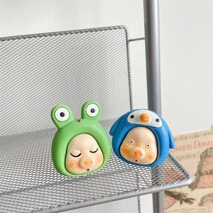 Detail of cute 3D cartoon pig phone grips in green frog and blue penguin hoodies