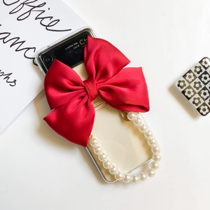Detail of Galaxy Z Flip clear case with red satin bow and pearl wrist strap chain