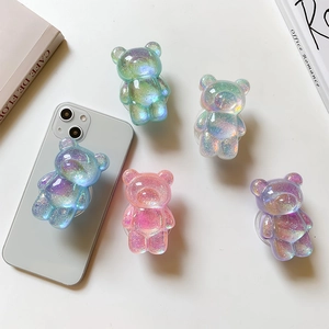 Detail view of five glittery bear-shaped collapsible phone grips in pastel gradient colors