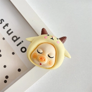 Close-up of cute cartoon resin charm featuring a sleeping baby in a yellow lamb hoodie