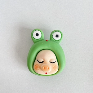 Close-up of cute 3D pig character with frog hat phone socket grip for mobile desk support