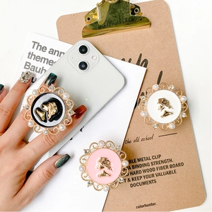 Detail showing vintage cameo phone grips with gold frames, pearls, and rhinestones