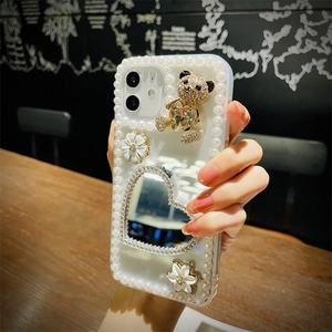 Detailed view of handmade iPhone case with pearl border, 3D gold bear, and heart mirror