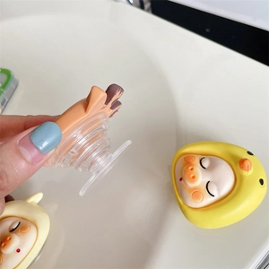 Close-up of cute 3D cartoon pig phone grip with yellow chick hat and flexible base