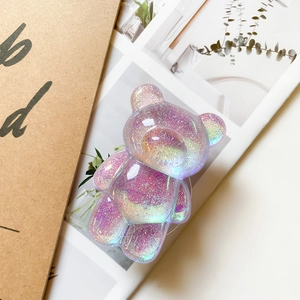 Close-up of a purple glittery bear phone grip with holographic laser resin texture