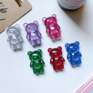 Flat lay of six colorful glittery bear phone grips in silver, purple, pink, green, red and blue