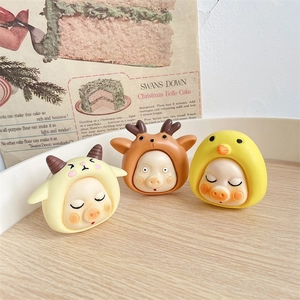 Detailed view of 3D cartoon pig phone stands with animal hats on a wooden surface