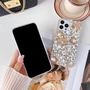 Detailed close-up of luxury iPhone case with rhinestones, pearl flowers and a gold crown