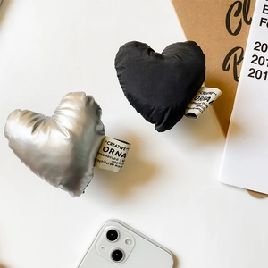 Détail de supports de téléphone en tissu en forme de cœur en argent et noir mat