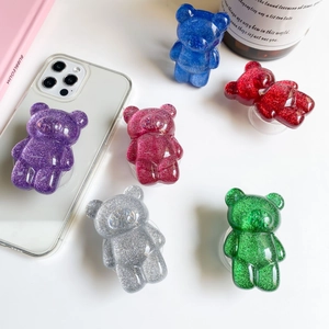 Close-up of glitter bear phone grip stands in purple blue red and silver colors