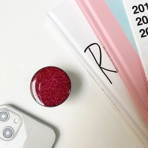 Close-up of a round phone socket stand featuring vibrant red glitter and a sleek black frame