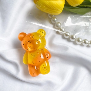 Orange gradient bear phone socket with gold foil flakes on a white fabric background