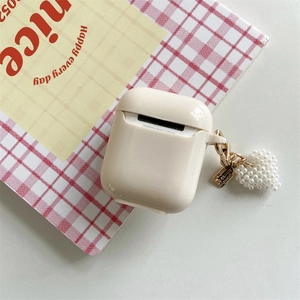 Dettaglio custodia AirPods crema con ciondolo a cuore in perle e catena dorata