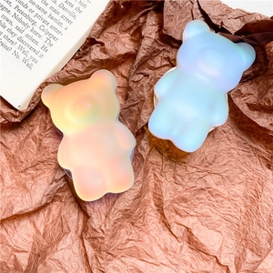 Close-up of bear-shaped phone grip with iridescent finish in orange and blue