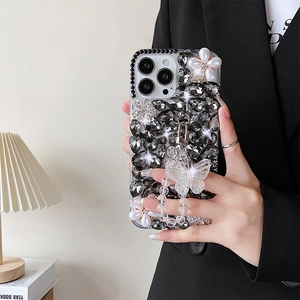 Detailed luxury iPhone case with black crystals, pearl flowers, and a butterfly bead lanyard