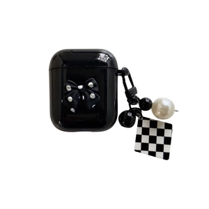 Dettaglio custodia AirPods nera con fiocco a pois e ciondolo a scacchi con perla