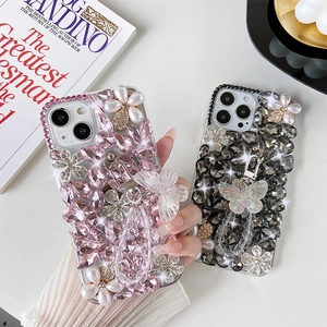 Close-up of luxury iPhone case featuring 3D acrylic butterflies and crystal floral charms