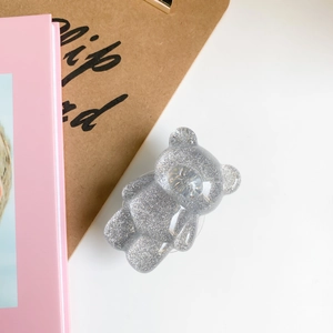 Macro view of a silver glitter bear phone grip with sparkling resin texture details