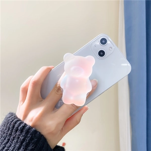 Close-up of translucent gradient pink 3D bear phone grip held by hand on a smartphone