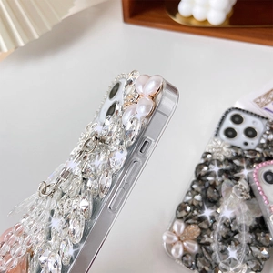 Detailed view of handmade luxury pearl and rhinestone flower patterns on iPhone case