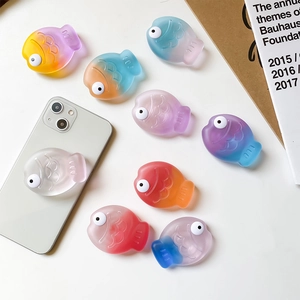 Flat lay of cute 3D fish phone grips in gradient colors with a matte resin finish