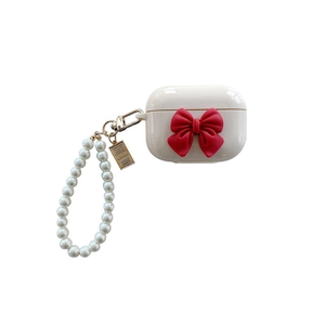 White AirPods Pro case with red 3D bow and pearl wrist strap on white background