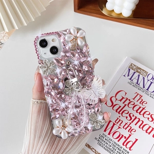 Detailed view of pink crystal rhinestones, pearl flowers, and a 3D butterfly phone case