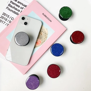Set of round glitter collapsible phone grips in six sparkling colors on aesthetic books
