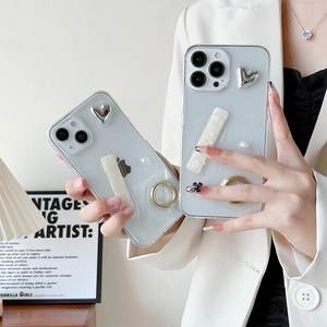 Detail showing translucent grey iPhone case with silver heart decor and ring holder stand