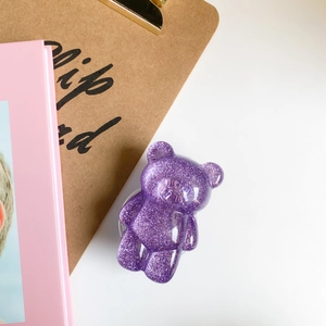 Close-up of cute purple glitter bear phone socket holder on a stylish desk background
