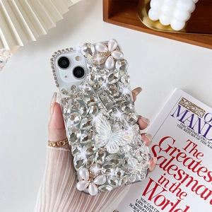 Detail of luxury iPhone case featuring silver rhinestones, pearls and butterfly charms