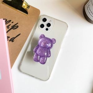 Detail of a purple glitter bear phone socket on a transparent case for iPhone models