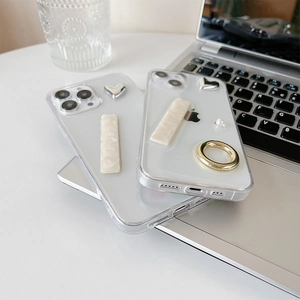 Detail of transparent iPhone case featuring silver heart, pearls, and metal ring grip