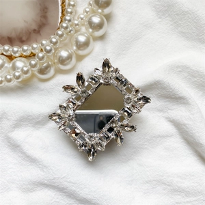 Detail of luxury rhinestone mirror phone grip with shimmering silver floral crystal frame